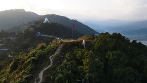 Flying-Towards-Mountain-Viewpoint-In-Pokhara,-Nepal-With-View-Of-World-Peace-Pagoda-In-Distance