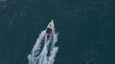 Speedboat-cruising-on-deep-blue-sea-off-Genoa-coast,-aerial-view,-daytime