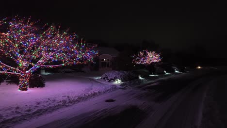 Multi-colored-Christmas-lights-on-trees-at-large-residential-home-in-USA-during-holiday-season