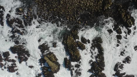 4K-cinematic-overhead-pullback-of-giant-waves-breaking-on-coastal-rocks