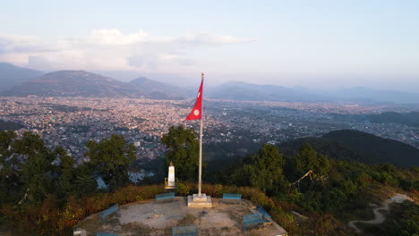 Paisaje-Matutino-En-El-Mirador-De-La-Montaña-Con-La-Bandera-De-Pokhara-Con-Vistas-Al-Lago-Phewa-Y-La-Ciudad-De-Pokhara-En-Nepal