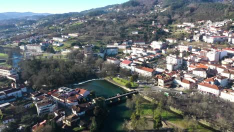 Drone-orbit-above-River-Vez-bridge-or-Ponte-da-Vila-and-town-of-Arcos-de-Valdevez-in-Portugal,-aerial-pan-establish
