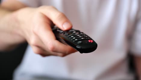 A-hand-browsing-TV-and-movie-channels-with-a-remote-control