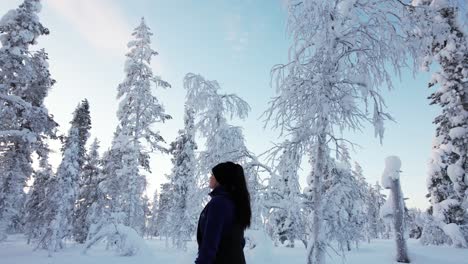 Girl-Explores-Her-Surroundings-In-Winter-Wonderland-Forest-in-Lapland,-Finland,-Arctic-Circle