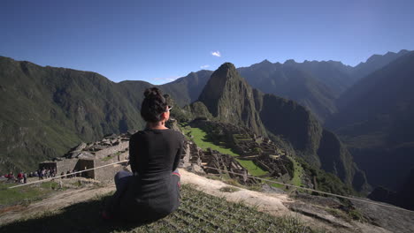An-asian-woman-admiring-the-view-of-the-majestic-Macchu-Picchu-in-Peru-right-in-front-of-her