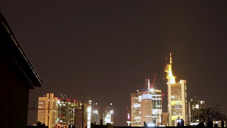 Nighttime-view-of-Frankfurt-skyline-with-illuminated-buildings-under-a-starry-sky,-timelapse
