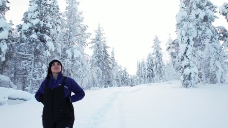 Girl-Taking-a-Stroll-In-Snowy-Landscape,-Admiring-the-Beauty-and-Trees-in-Lapland,-Finland,-Arctic-Circle
