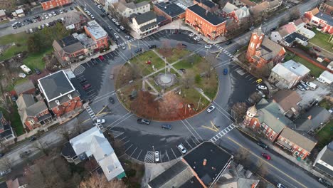 Traffic-on-roundabout-in-small-american-City-with-playground-park-and-american-flag-in-center