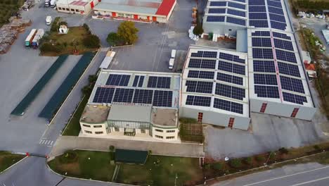 Rooftop-solar-power-setup-at-storage-depot-center,-aerial-view-over-site-and-parking-lot