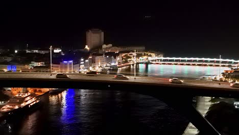 Drohne-Erhebt-Sich-über-Der-Brücke,-Während-Lichter-Auf-Dem-Wasser-Unterhalb-Der-Handelskade-Willemstad-Curacao-Schimmern