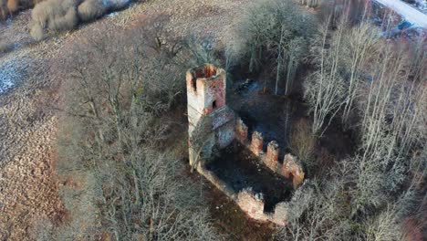 Aerial-view-of-old-neglected-church-bell-tower-and-wall-remains-in-countryside