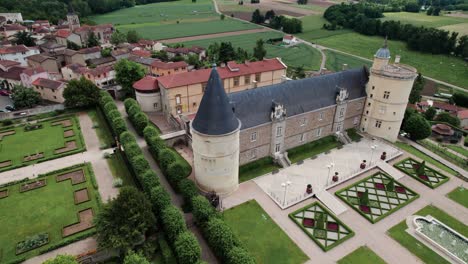 drone-shot-over-the-chateau-de-boutheon-with-the-plaine-du-forez-in-the-background-on-a-summer-sunny-day,-Andrezieux-Boutheon,-Loire-departement,-France