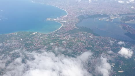 Vista-Aérea-Panorámica-Del-Paisaje-Balinés-Y-El-Océano-A-Través-De-Las-Nubes-En-El-Popular-Destino-Turístico-De-Bali,-Indonesia,-Sudeste-Asiático