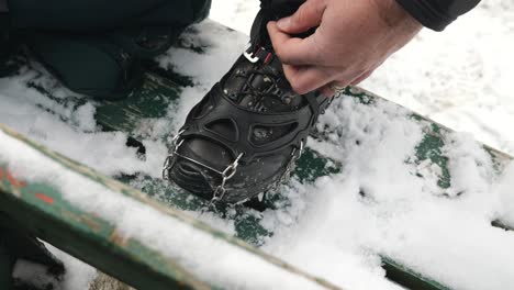 a-hiker-putting-crampon-on-his-winter-boots
