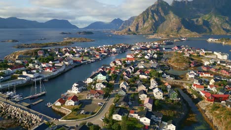 Drone-flight-over-Henningsaer-in-the-lofoten-islands,-revealing-shot-of-the-arctic-village-with-beautiful-backdrop