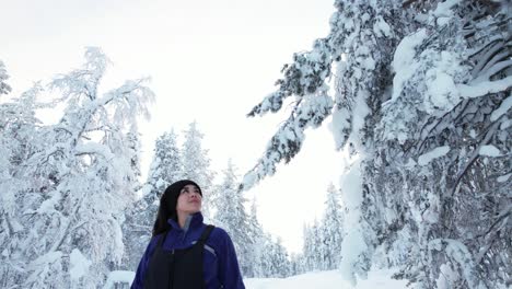 Girl-Walking-In-Snowy-Landscape,-Admiring-the-Beauty-and-Trees-in-Lapland,-Finland,-Arctic-Circle
