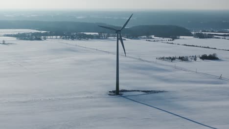 Drohne-Umkreist-Eine-Einsame-Windkraftanlage-Inmitten-Der-Verschneiten-Ostseelandschaft