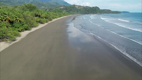 Flying-above-wet-beach-during-low-tide-in-Costa-Rica