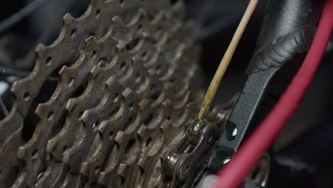 Bike-chain-lubricant-dripped-onto-links-in-maintenance-shop-closeup