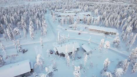 Drone-Aéreo-Volando-A-Través-De-Un-Barrio-Cubierto-De-Nieve-En-Laponia,-Finlandia,-Círculo-Polar-ártico