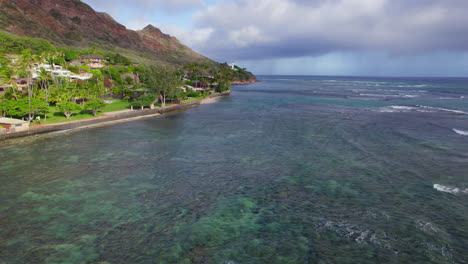 drone-footage-along-the-island-coast-of-Oahu-Hawaii-with-coral-reefs-showing-through-the-crystal-clear-water-of-the-Pacific-Ocean-near-Honolulu