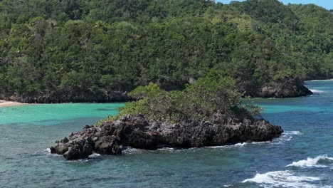 Rocky-island-with-growing-plants-at-bay-of-samana-during-sunny-day