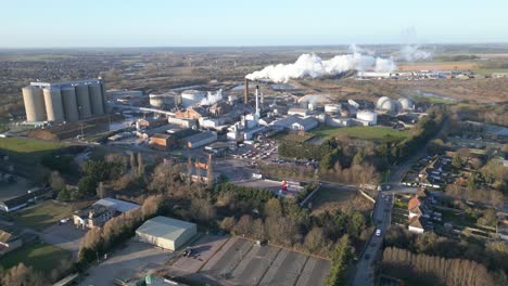 Bury-st-edmunds-with-industrial-complex-and-smokestacks,-clear-day,-aerial-view