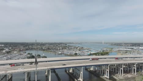 An-aerial-view-of-the-Kemah-Bridge-with-a-new-span,-featuring-Clear-Lake-and-Seabrook-Marina-in-the-background,-in-Kemah,-Texas