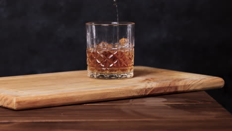 Whiskey-on-the-rocks,-dark-background-wooden-table