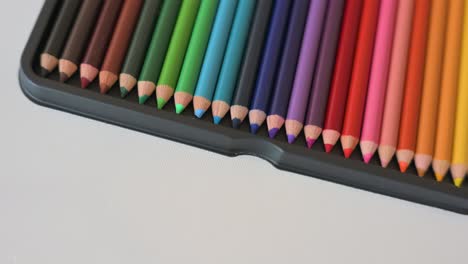Closeup-of-color-pencils-arranged-in-a-rainbow-pattern-slowly-rotating-from-above