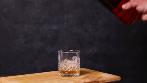 Whiskey-on-the-rocks,-dark-background-wooden-table