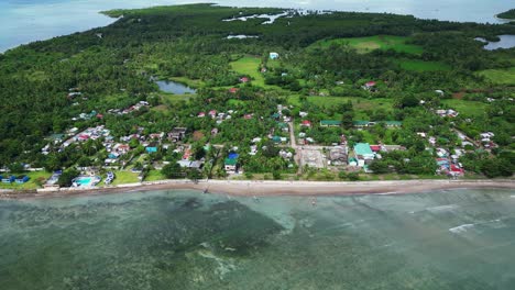 Overhead-drone-view-of-quaint,-coastal-Philippine-village-on-lush-tropical-island