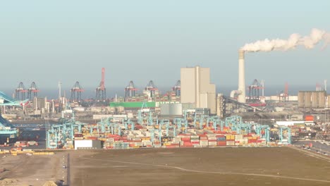 Zoomed-drone-trucking-shot-of-automated-stacking-cranes-moving-on-a-container-terminal