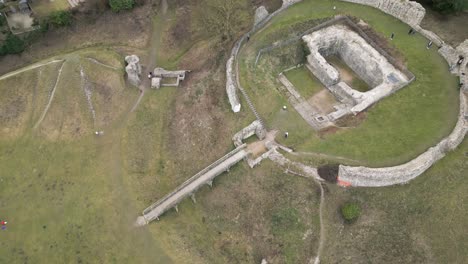 Spiral-Rising-Drone-View-of-Castle-Acre-Ruins-and-Bailey-Gate,-Norwich-UK