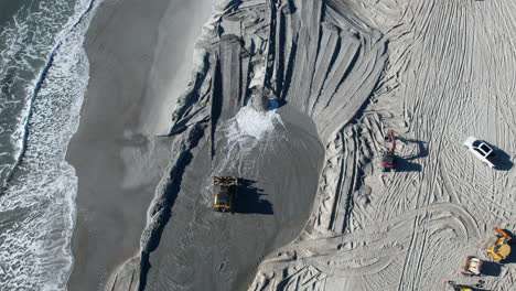 Aerial-shot-of-beach-nourishment,-or-adding-sand-or-sediment-to-beaches-to-combat-erosion,-can-have-negative-impacts-on-wildlife-and-ecosystems