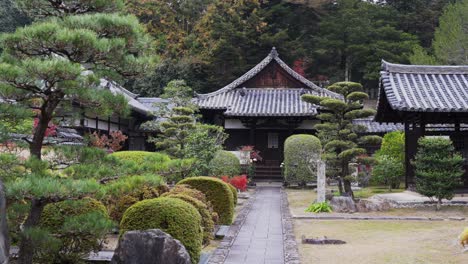 Traditional-Japanese-temple-surrounded-by-manicured-gardens,-serene-setting