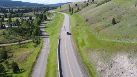 on-a-summer-day,-a-truck-passes-through-the-beautiful-green-landscape-in-British-Columbia