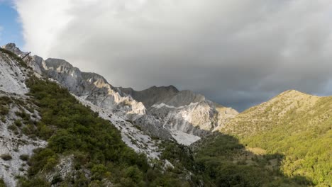Majestuosa-Cordillera-En-Toscana-Con-Picos-Iluminados-Por-El-Sol-Y-Nubes-Inminentes,-Hiperlapso-Aéreo