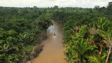 An-aerial-4K-drone-view-of-a-longtail-boat-sailing-down-a-river-in-the-jungle