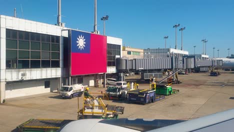 Exterior-view-of-Taiwan-Taoyuan-International-Airport-terminal-building-with-a-large-Taiwanese-flag