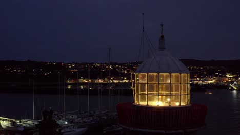 Aerial-orbit-around-Howth-Harbour's-lighthouse-lantern-at-night