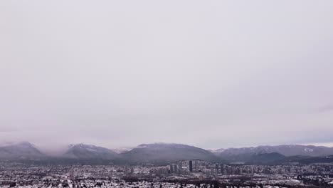 camera-tilts-down-revealing-snow-covered-mountains-and-a-cityscape