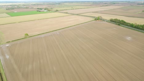 Drone-footage-at-400-feet-flying-over-farmer's-fields-in-the-UK-autumn-with-fields-and-then-coastline-right-into-the-distance