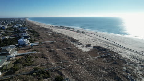 Drone-shot-of-beach-nourishment,-or-adding-sand-or-sediment-to-beaches-to-combat-erosion,-can-have-negative-impacts-on-wildlife-and-ecosystems,-with-water-coming-out-of-pipe
