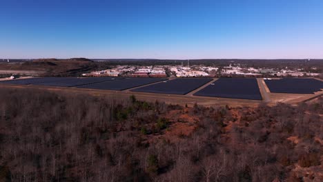 An-aerial-view-over-a-large-solar-field-on-Long-Island,-New-York-on-a-sunny-day-with-blue-skies
