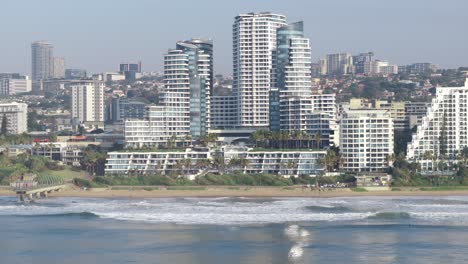 Coastal-view-of-uMhlanga,-Durban-with-modern-buildings-overlooking-the-beach,-clear-sky