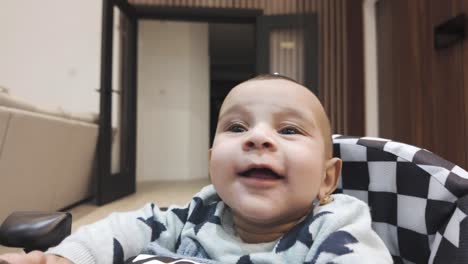 A-heartwarming-moment-captured-as-a-4-month-old-joyfully-sits-in-a-baby-walker,-radiating-adorable-smiles,-a-delightful-scene-showcasing-the-early-stages-of-a-baby's-development-and-happiness