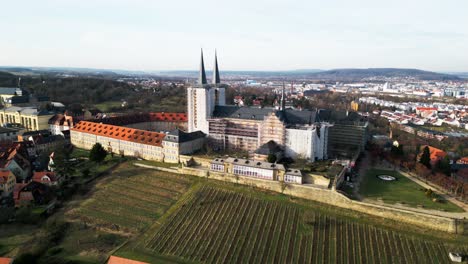 Bamberg-Kloster-Michelsberg-Drone-video-flying-away-revealing-cityscape-and-vineyard