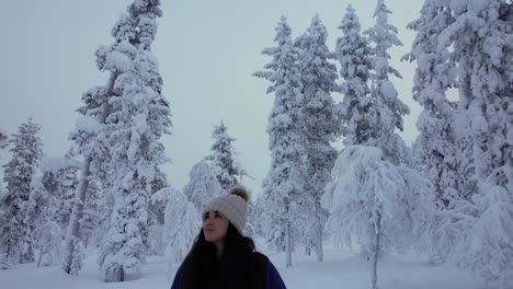 Hermosa-Chica-Explorando-Paisajes-En-Un-Bosque-Nevado-En-Laponia,-Finlandia,-Círculo-Polar-ártico