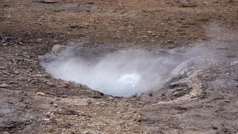 Dampfende-Geothermische-Quelle-In-Felsigem-Isländischen-Gelände-Mit-Sichtbarem-Wasserausbruch